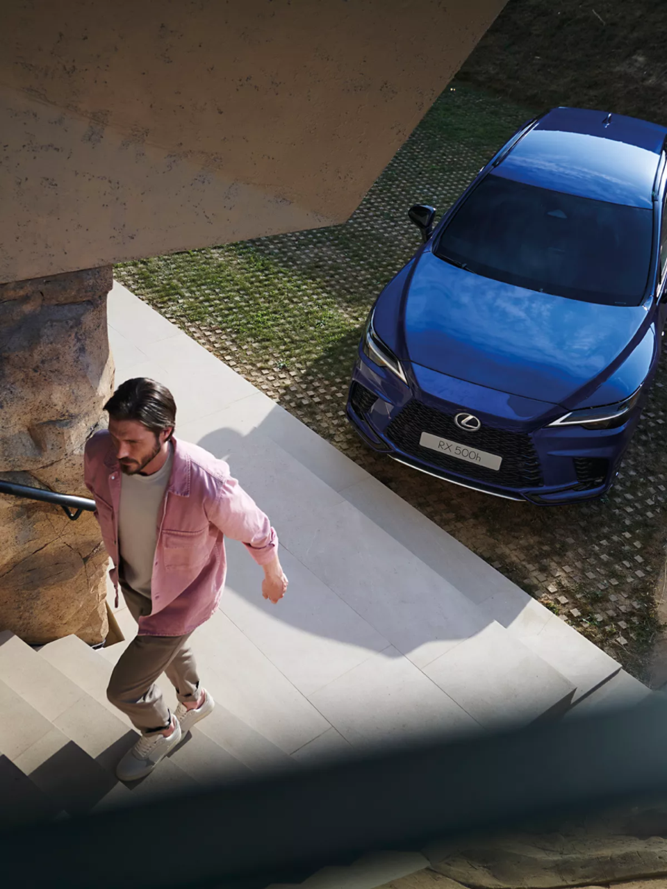 A person walking up steps next to a blue Lexus RX 500h.