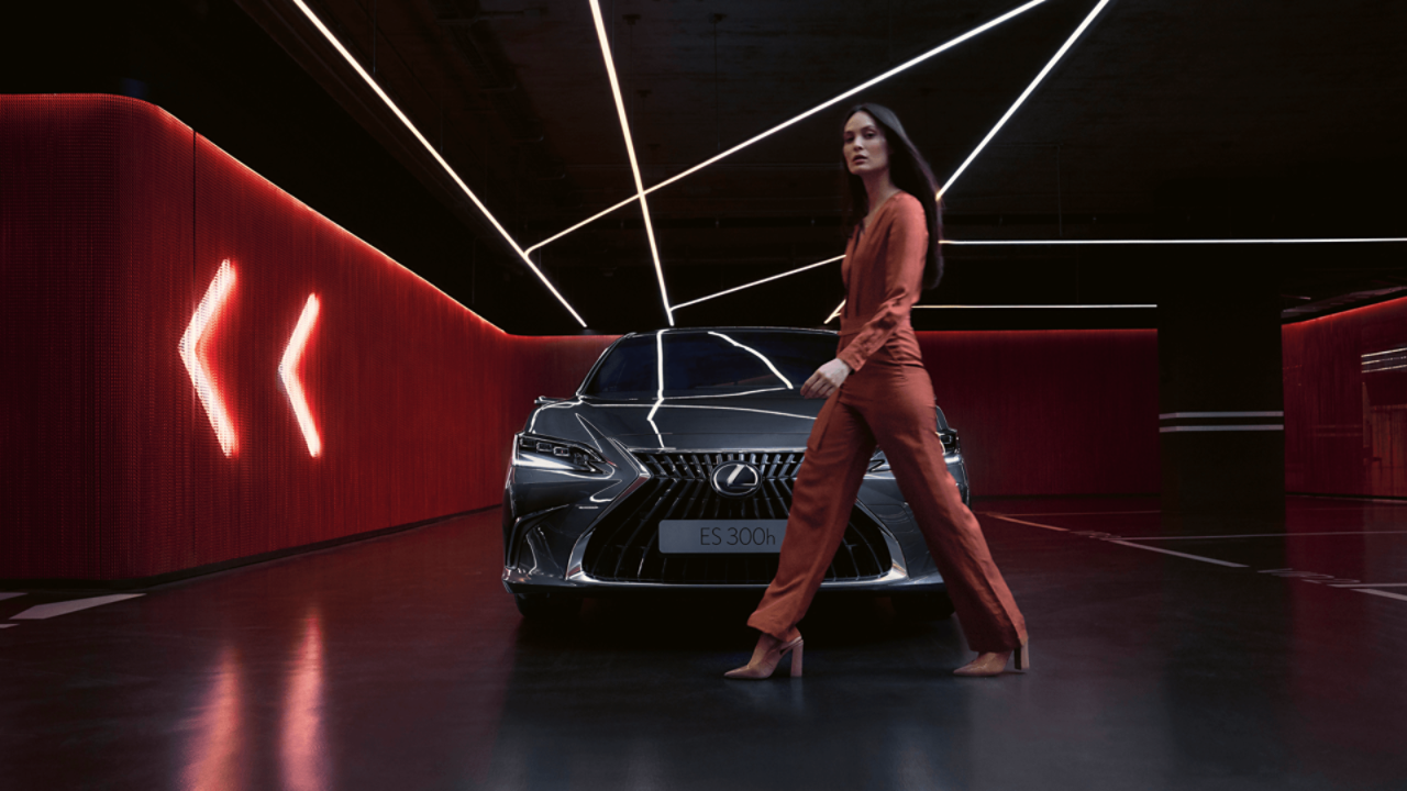 A woman walking past a Lexus ES 300h