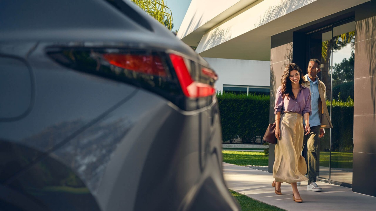 A man and woman approaching a Lexus NX